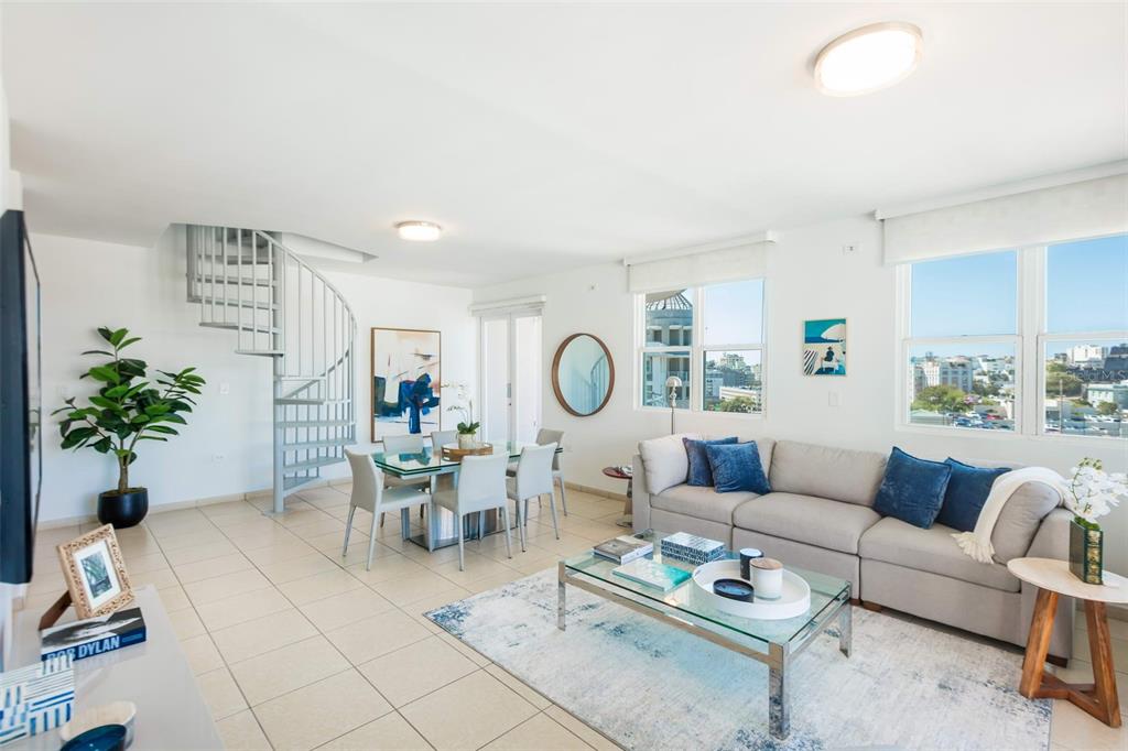 A living and dining area features a spiral staircase, tile flooring, and large windows — Cond Capitolio Plaza CALLE DEL MUELLE UNIT 21007, SAN JUAN, PR