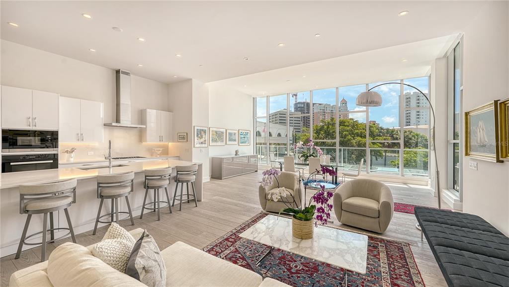 A modern open-concept living room and kitchen with floor-to-ceiling windows and light wood flooring — 1335 2ND STREET UNIT Villa 2E, SARASOTA, FL