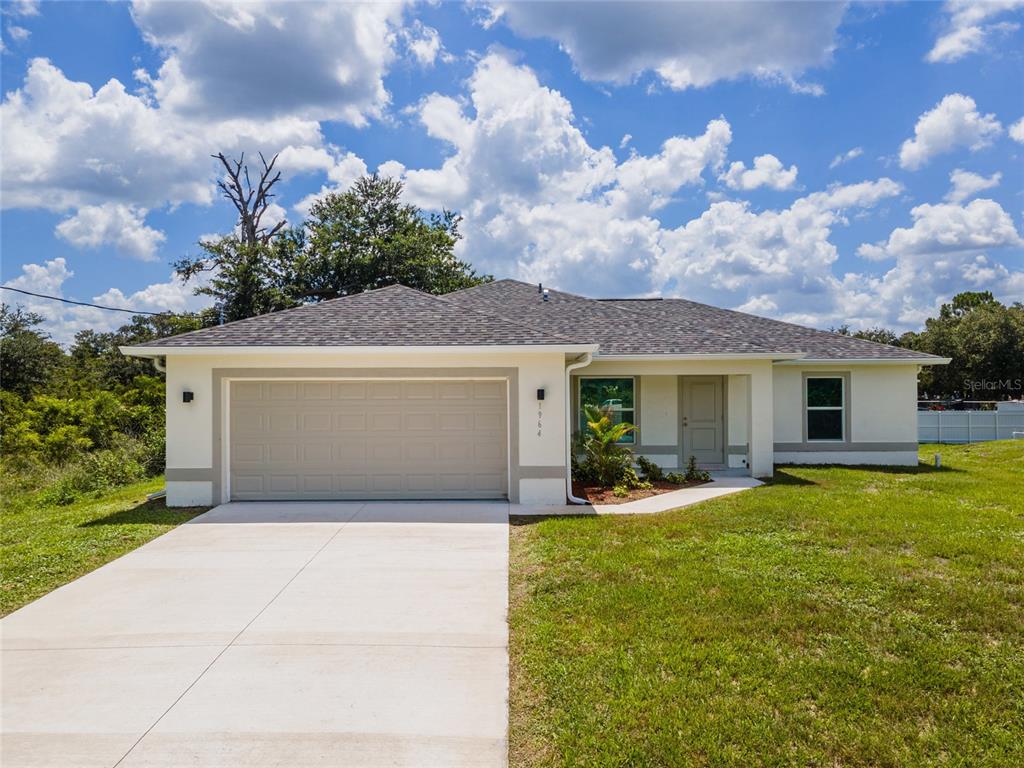 A single-story house with a beige garage, white stucco walls, and a gray shingled roof — 1964 LEGHORN STREET, LEHIGH ACRES, FL