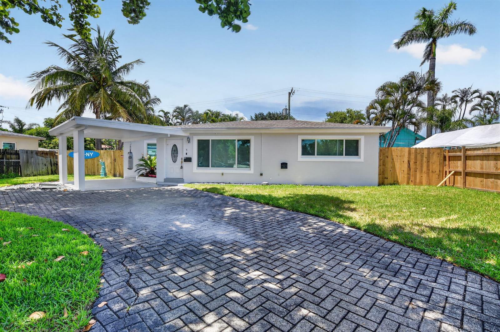 A single-story house with a paved driveway, a carport, and a wooden fence — 155 NE 20th Street, Boca Raton FL 33431, BOCA RATON, FL