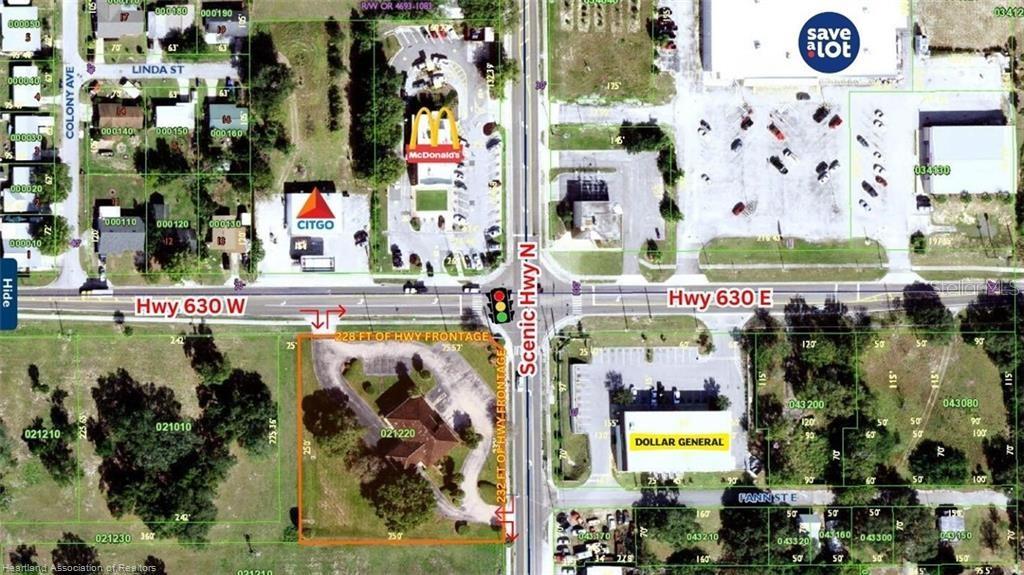 This is an aerial map showing a commercial property outlined in orange near an intersection — 695 N SCENIC HIGHWAY, FROSTPROOF, FL