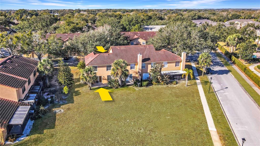 An aerial view shows the rear exterior of a two-story townhouse with a grassy yard — 1192 N FAIRWAY DRIVE, APOPKA, FL