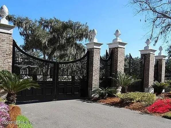 A black metal gate is set between brick pillars topped with stone finials — Tbd Waterford Lane, FL 32097, FL