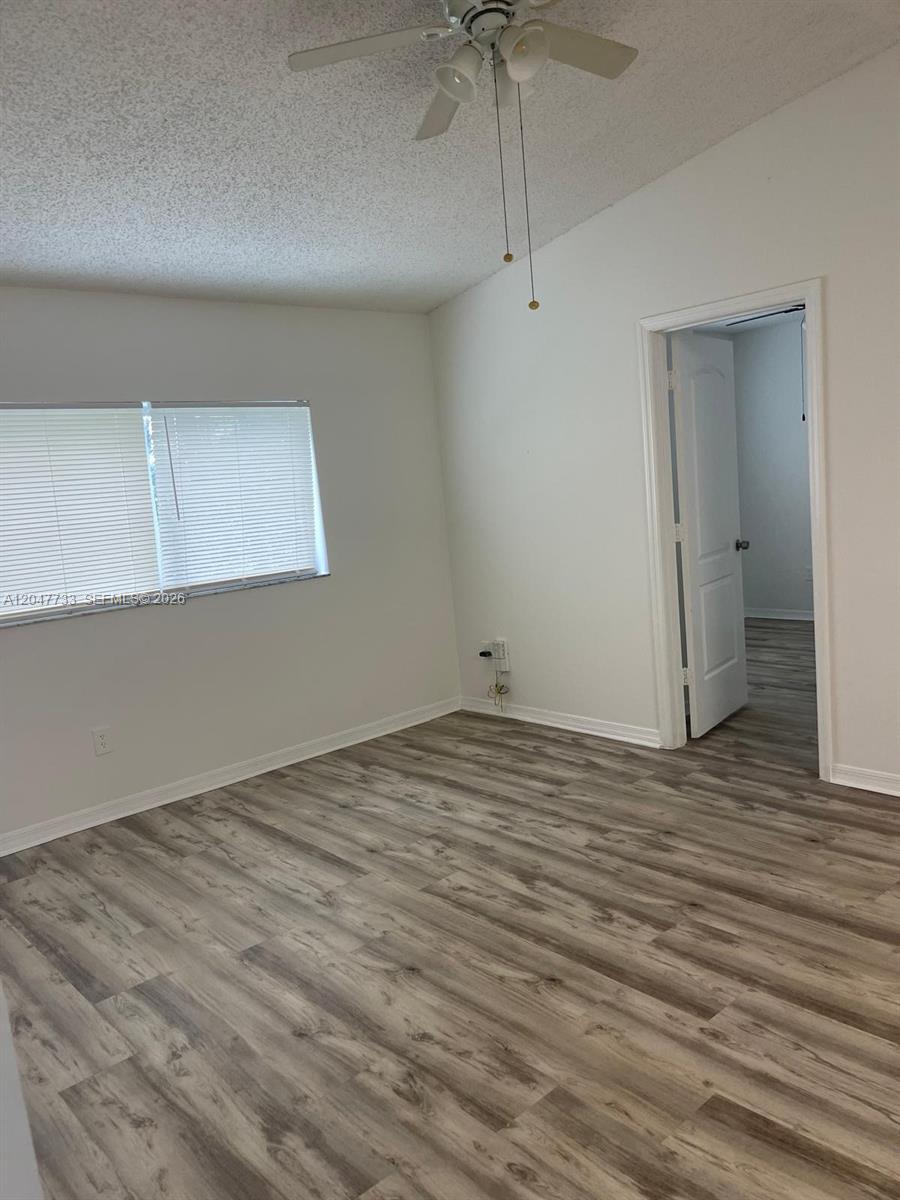An empty bedroom features light wood-look flooring, white walls, a ceiling fan, and a doorway — 3660 N 56th Ave # 601, Hollywood FL 33021, HOLLYWOOD, FL