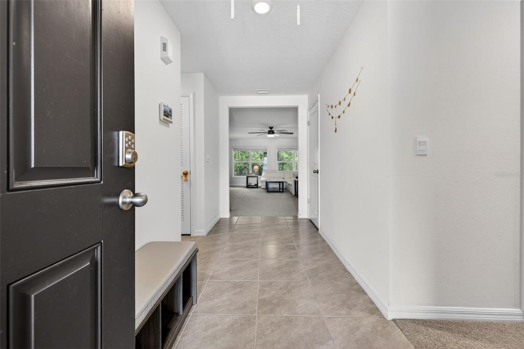 A tiled entryway leads to a living area with a ceiling fan and large windows — 5442 DIANTHA WAY, BROOKSVILLE, FL