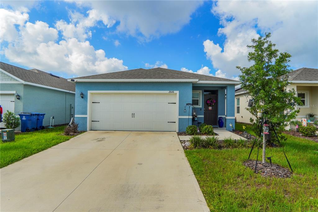 A blue single-story house with a two-car garage and a concrete driveway — 2606 ANGEL FALLS DRIVE, DAVENPORT, FL