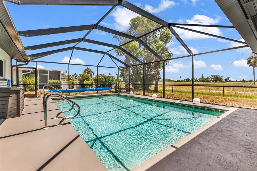 A screened-in swimming pool with a metal frame enclosure and a concrete deck — 82 ROTONDA CIRCLE, ROTONDA WEST, FL
