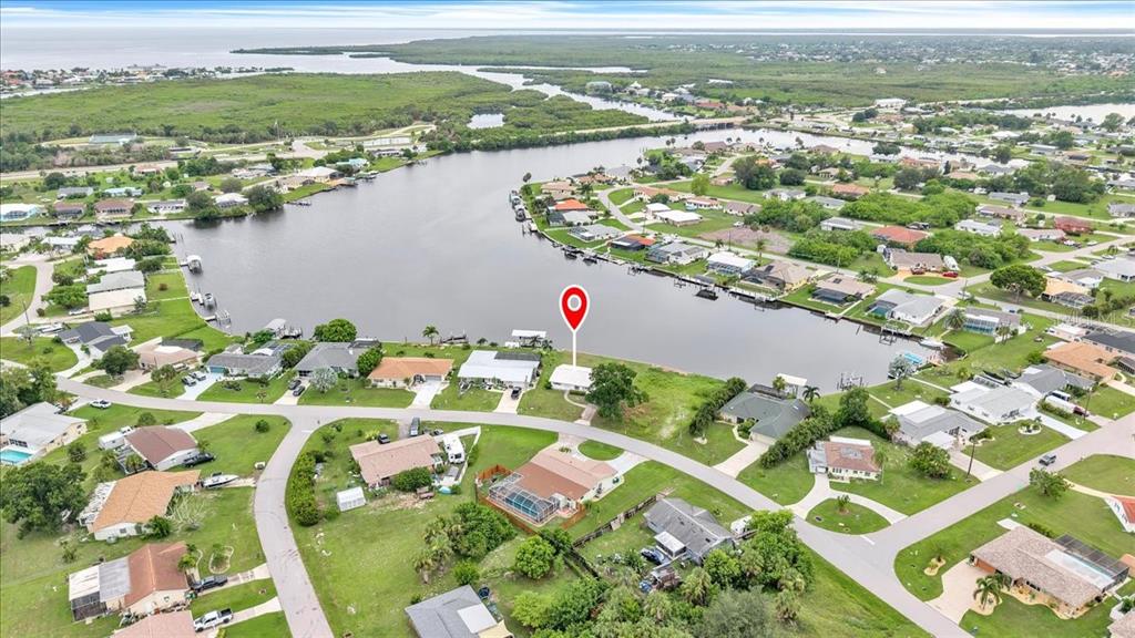 An aerial view shows a waterfront house marked with a pin on a canal — 3395 PINETREE STREET, PORT CHARLOTTE, FL