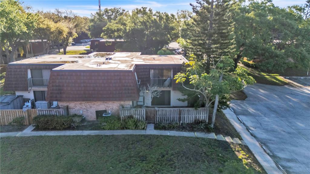 An aerial view of a two-story townhouse with a brown mansard roof and wooden fencing — 2605 10TH COURT, PALM HARBOR, FL