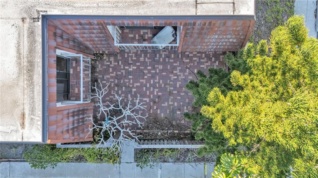 An aerial view shows a brick-paved courtyard with a bare tree and a large evergreen — 2605 10TH COURT, PALM HARBOR, FL