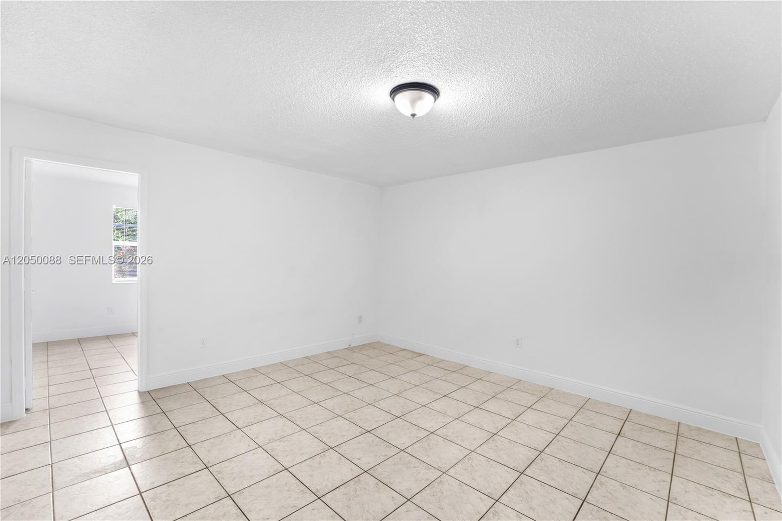 An empty room features white walls, a tiled floor, and a central ceiling light fixture — 1305 W 53rd St # 420, Hialeah FL 33012, HIALEAH, FL