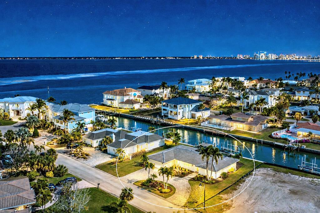 An aerial view of a waterfront house with a paved driveway and palm trees at night — 548 GUNWALE LANE, LONGBOAT KEY, FL