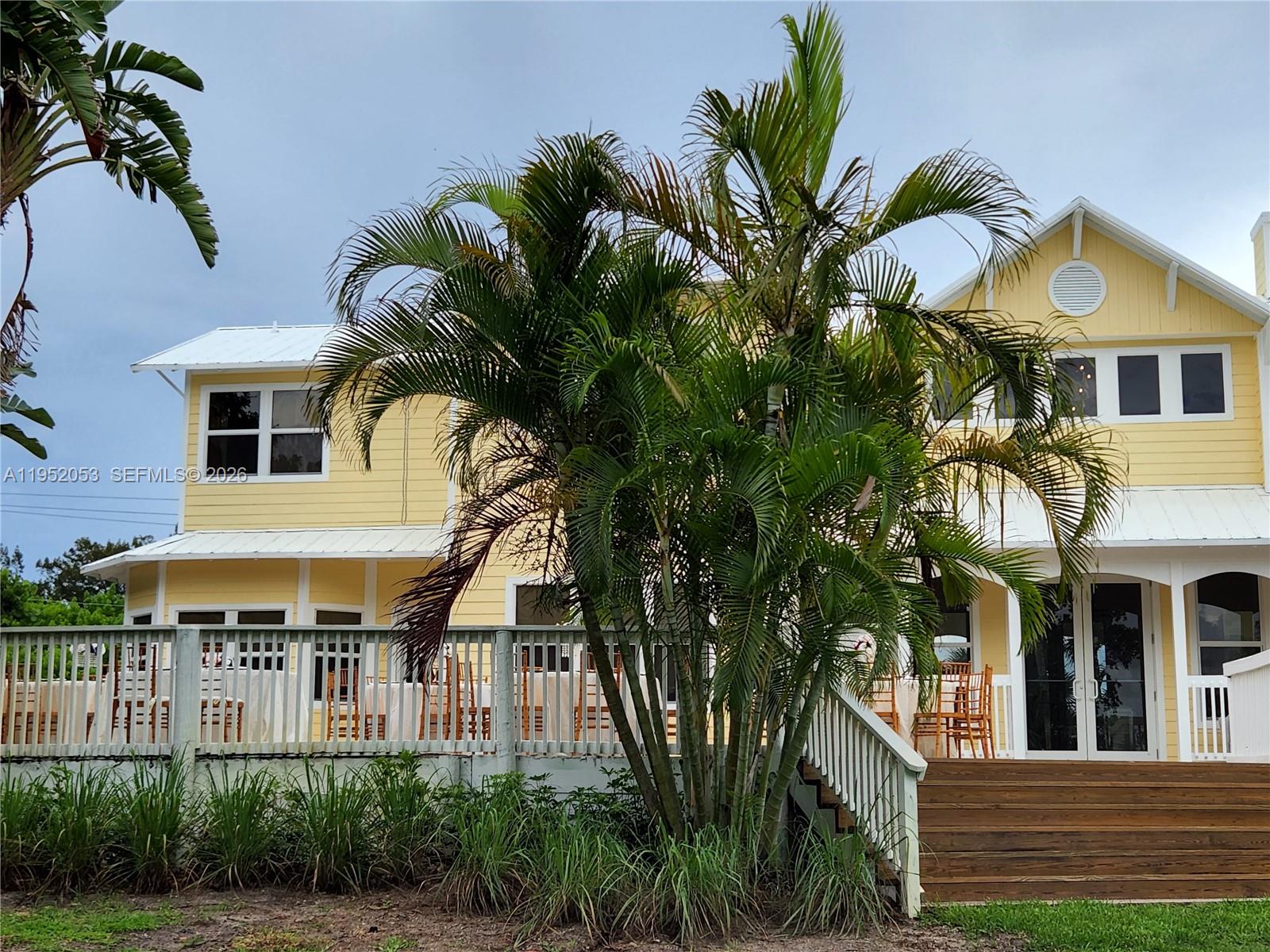A yellow two-story house features a wooden deck, a white railing, and a palm tree — 3601 N Highway A1a, Fort Pierce FL 34949, FORT PIERCE, FL