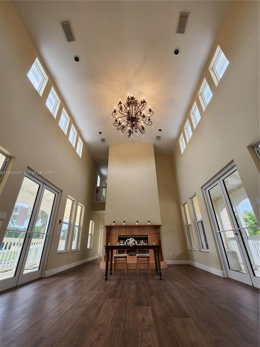 A high-ceilinged living room features a central fireplace, dark wood flooring, and multiple windows — 3601 N Highway A1a, Fort Pierce FL 34949, FORT PIERCE, FL