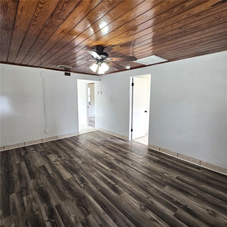 A room with wood-paneled ceilings, a ceiling fan, and dark wood-look flooring — 2710 AVENUE J NW, WINTER HAVEN, FL