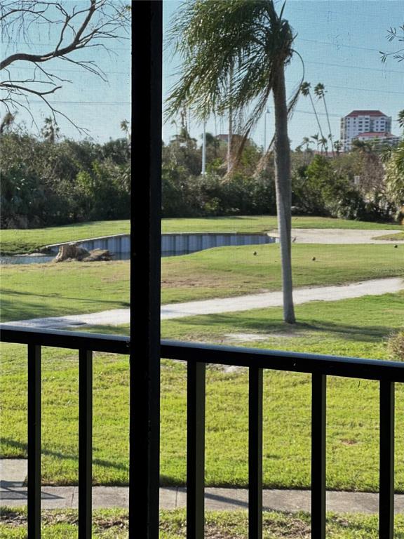 A view of a golf course and a pond from a screened-in balcony — 6219 PALMA DEL MAR BOULEVARD S UNIT 210, ST PETERSBURG, FL