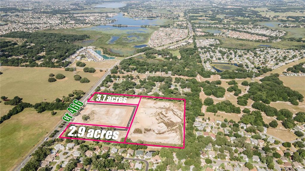 This aerial view shows two adjacent plots of land outlined in pink near a road — 1135 HWY 466, LADY LAKE, FL