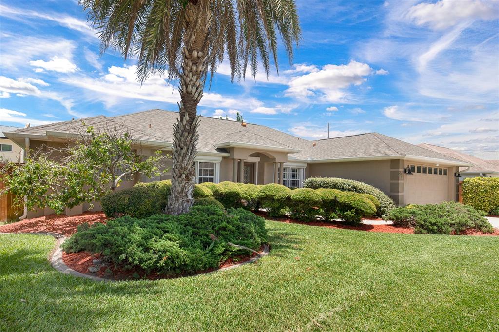 A single-story house with a palm tree, manicured hedges, and a two-car garage — 241 CORONA AVENUE, COCOA BEACH, FL