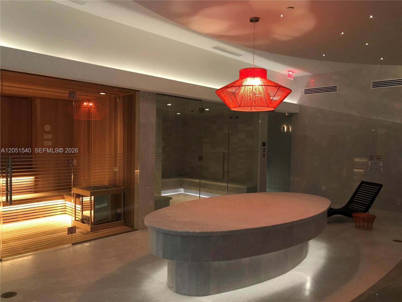 A spa room features a sauna, a steam room, a central stone table, and red lighting — 1010 Brickell Ave # 3309, Miami FL 33131, MIAMI, FL