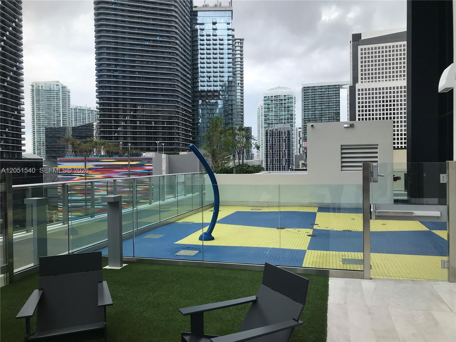 An outdoor terrace features a blue and yellow tiled splash pad and artificial grass area — 1010 Brickell Ave # 3309, Miami FL 33131, MIAMI, FL