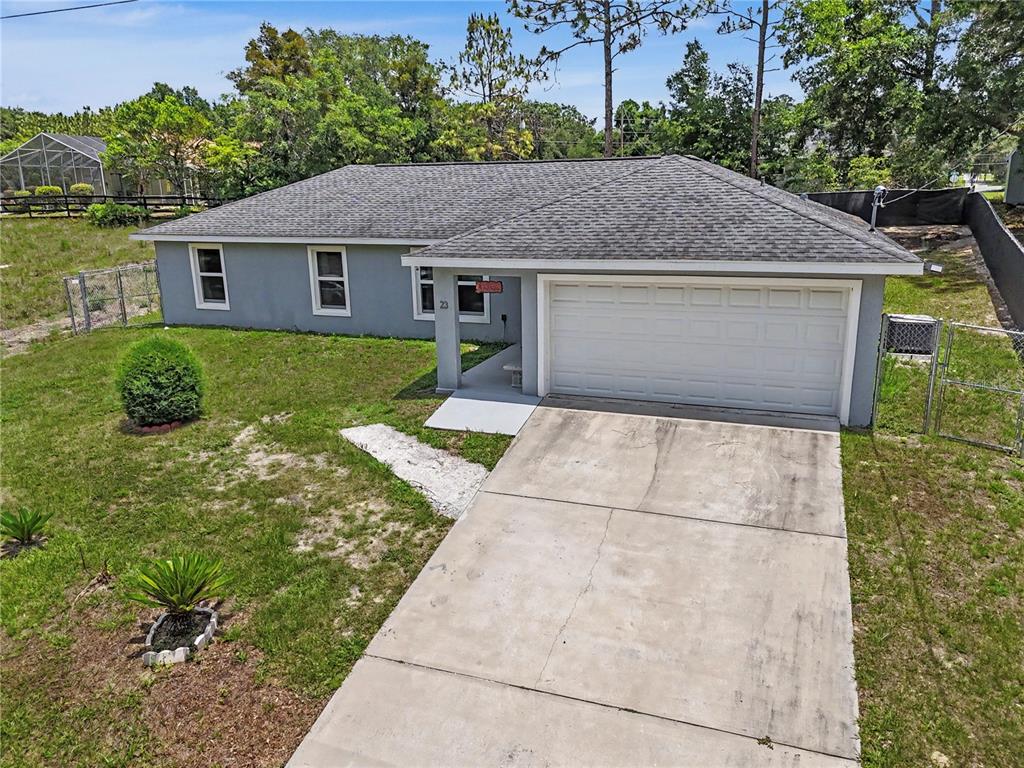 An aerial view of a gray, single-story house with a concrete driveway and fenced yard — 23 JUNIPER TRAIL CIRCLE, OCALA, FL