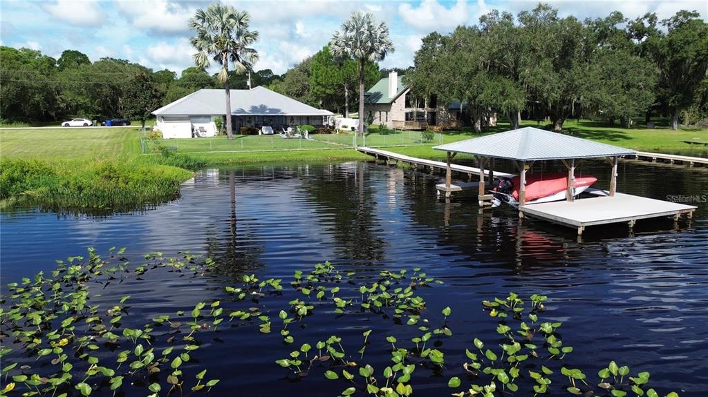 An aerial view shows a house with a red location pin beside a large lake — 2608 PINE NEEDLE DRIVE, SEBRING, FL