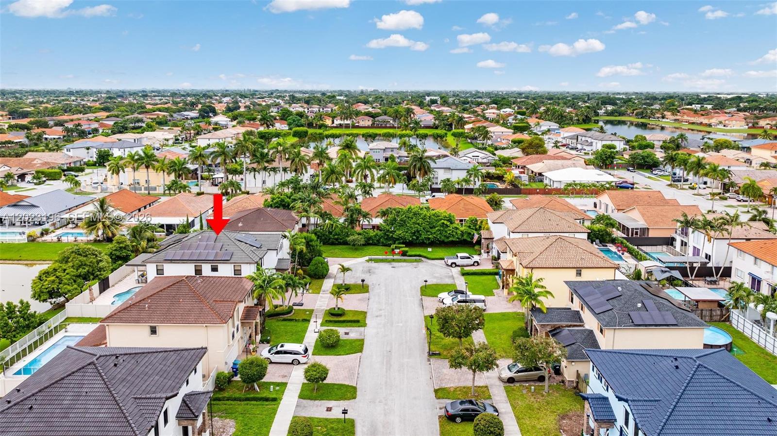 An aerial view shows a suburban neighborhood with houses featuring tiled roofs and solar panels — 16125 SW 65th Ln, Miami FL 33193, MIAMI, FL