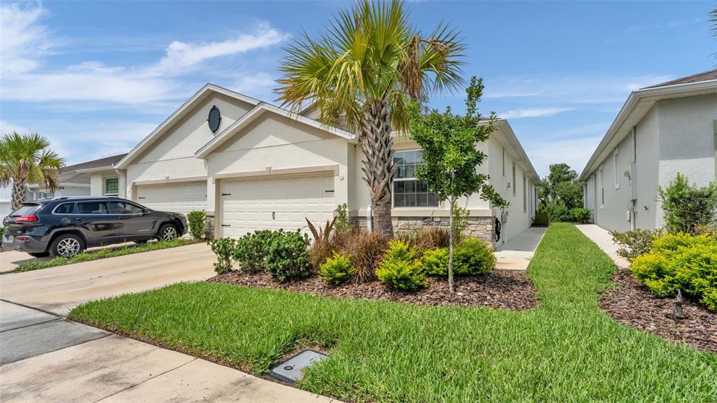 A beige single-story house with a two-car garage, a palm tree, and a parked SUV — 3817 STORMY THISTLE PLACE, PLANT CITY, FL