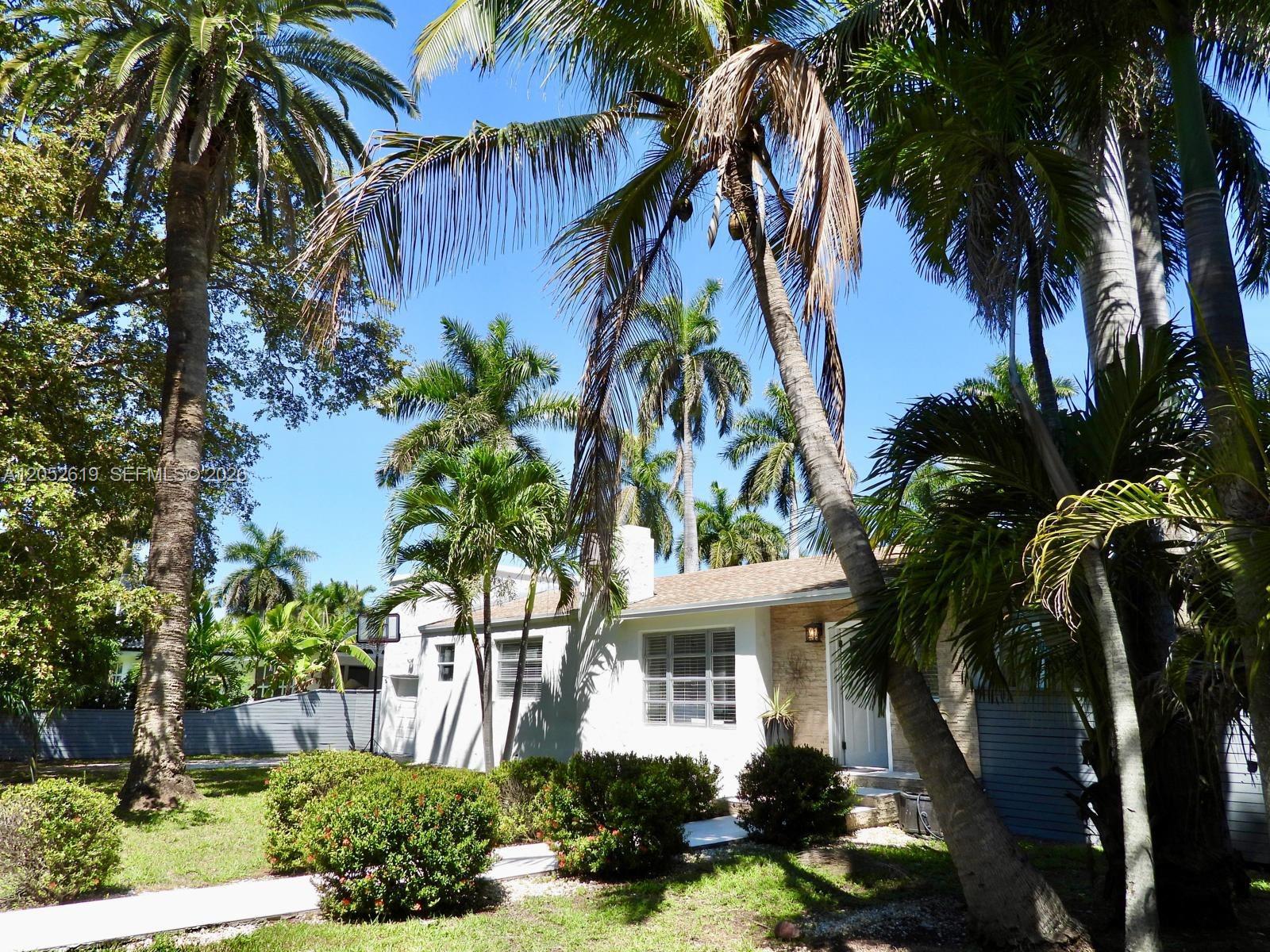 A single-story house with a white exterior and stone accents is surrounded by palm trees — 715 Hollywood Blvd, Hollywood FL 33019, HOLLYWOOD, FL