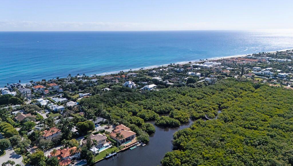 An aerial view shows coastal homes nestled between a dense forest and the ocean — 6064 N Ocean Boulevard, Ocean Ridge FL 33435, OCEAN RIDGE, FL