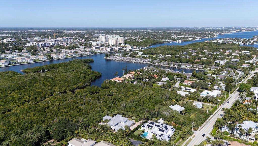 An aerial view shows a coastal neighborhood with houses, dense trees, and a winding waterway — 6064 N Ocean Boulevard, Ocean Ridge FL 33435, OCEAN RIDGE, FL