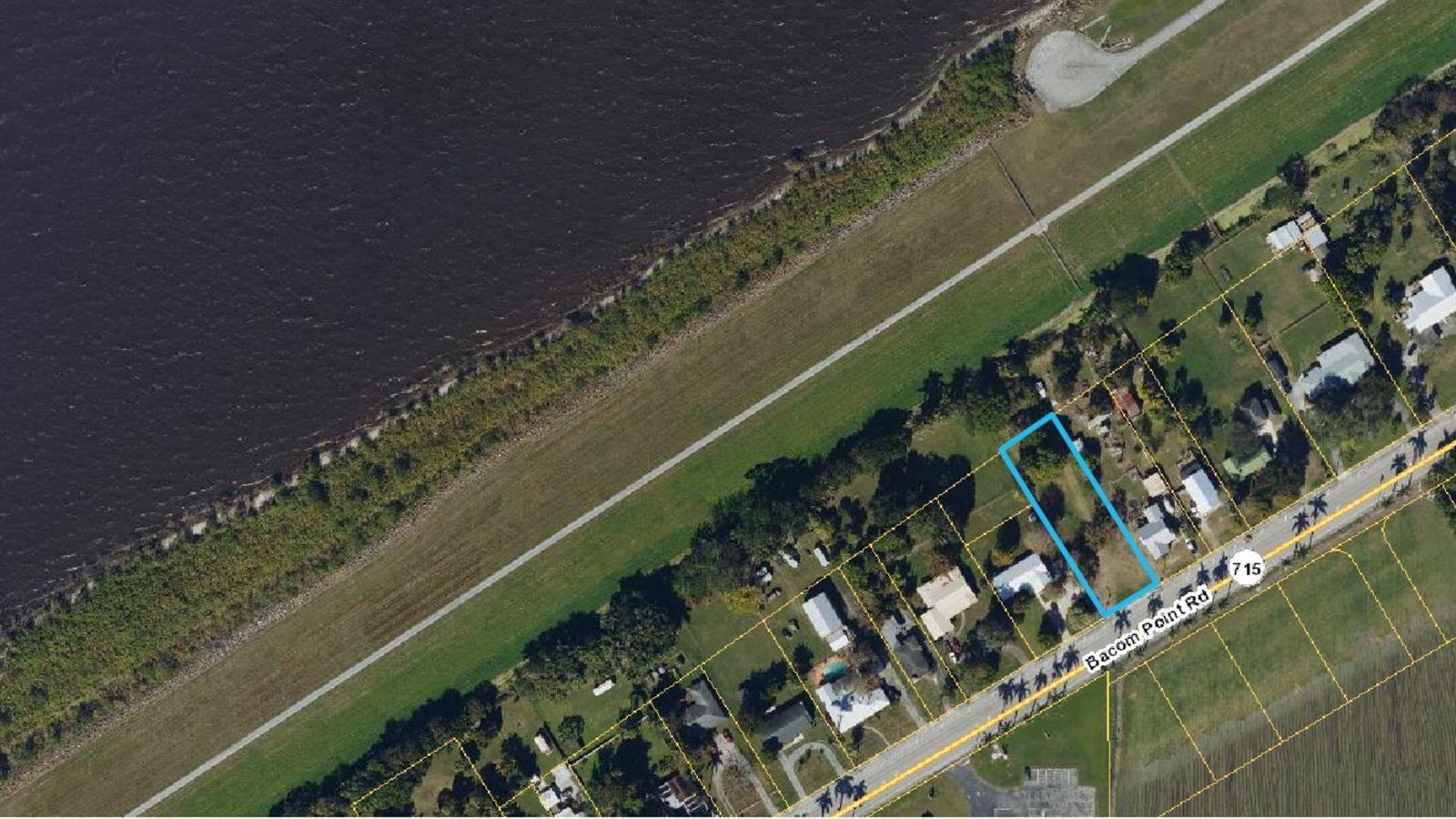 An aerial view shows a rectangular residential lot outlined in blue along a coastal road — 1697 Bacom Point Road, Pahokee FL 33476, PAHOKEE, FL
