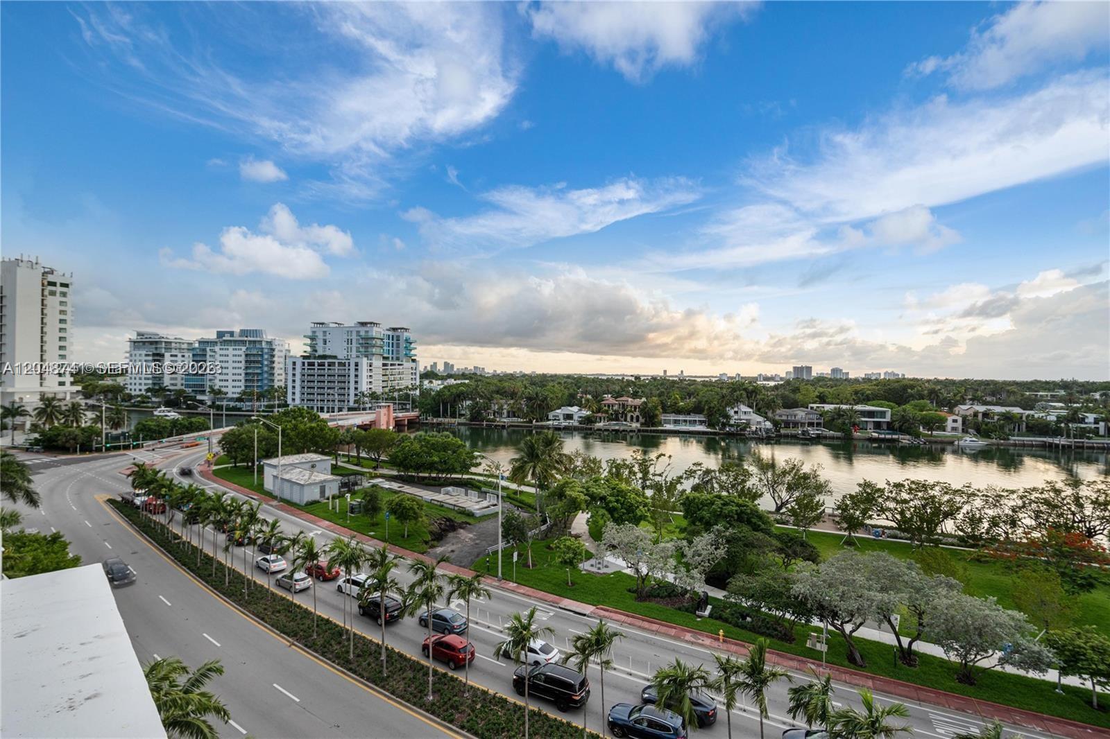 An elevated view shows a road with cars, a park, a waterway, and distant buildings — 6362 Collins Ave # 614, Miami Beach FL 33141, MIAMI BEACH, FL