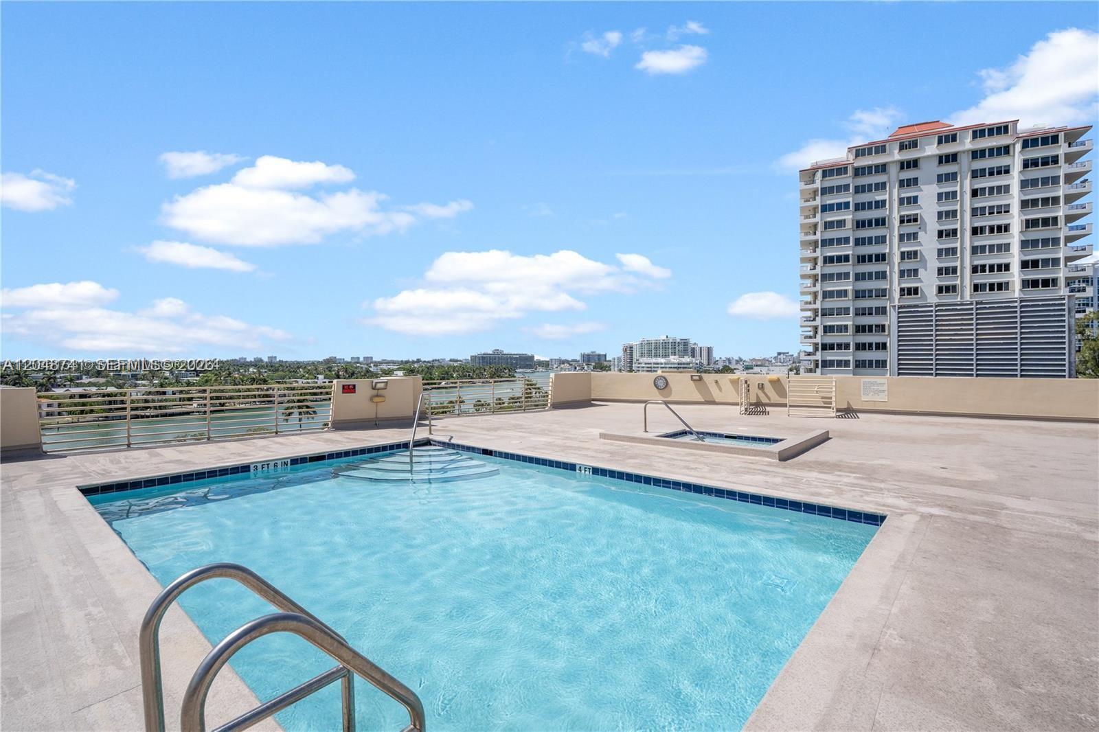 A rooftop swimming pool and hot tub overlook a city skyline and a waterway — 6362 Collins Ave # 614, Miami Beach FL 33141, MIAMI BEACH, FL
