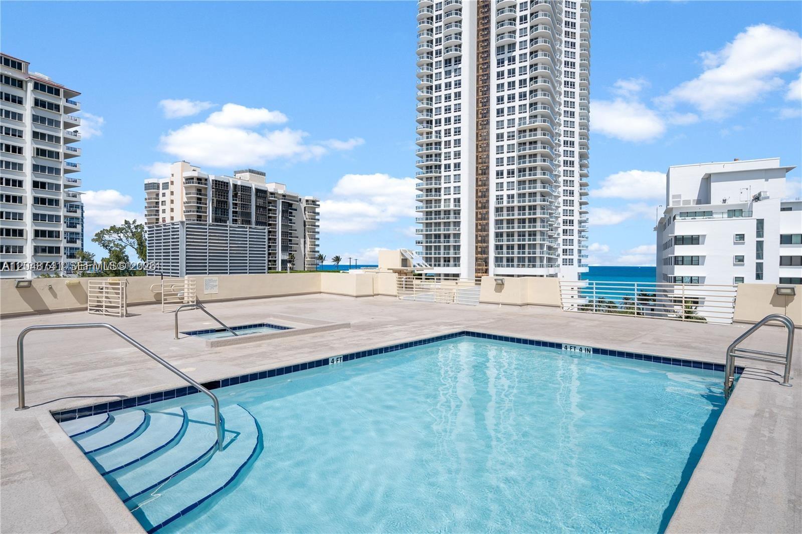An outdoor swimming pool and hot tub are situated on a rooftop terrace overlooking the ocean — 6362 Collins Ave # 614, Miami Beach FL 33141, MIAMI BEACH, FL