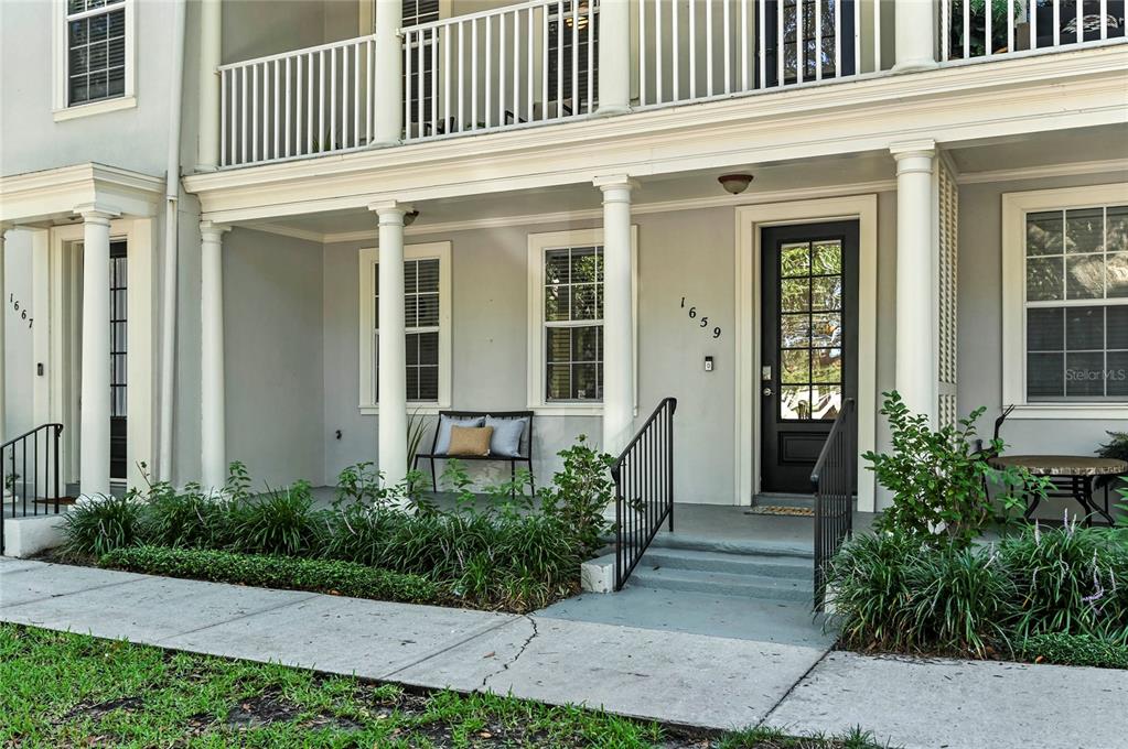 The exterior of a two-story townhouse features a covered front porch with white columns — 1659 COMMON WAY ROAD, ORLANDO, FL