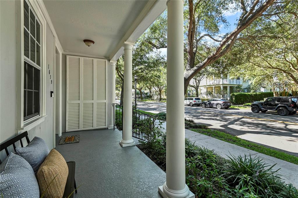 A covered front porch features white columns, a gray floor, and a view of the street — 1659 COMMON WAY ROAD, ORLANDO, FL