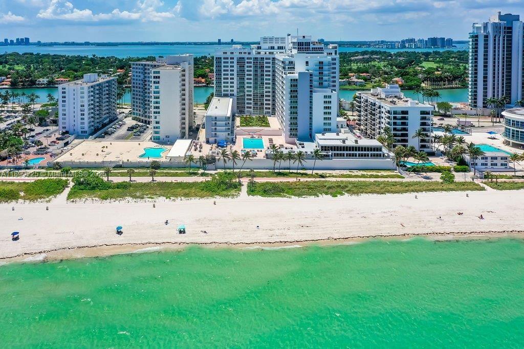 An aerial view of a beachfront condominium complex with swimming pools and surrounding landscape — 5401 Collins Ave # 729, Miami Beach FL 33140, MIAMI BEACH, FL