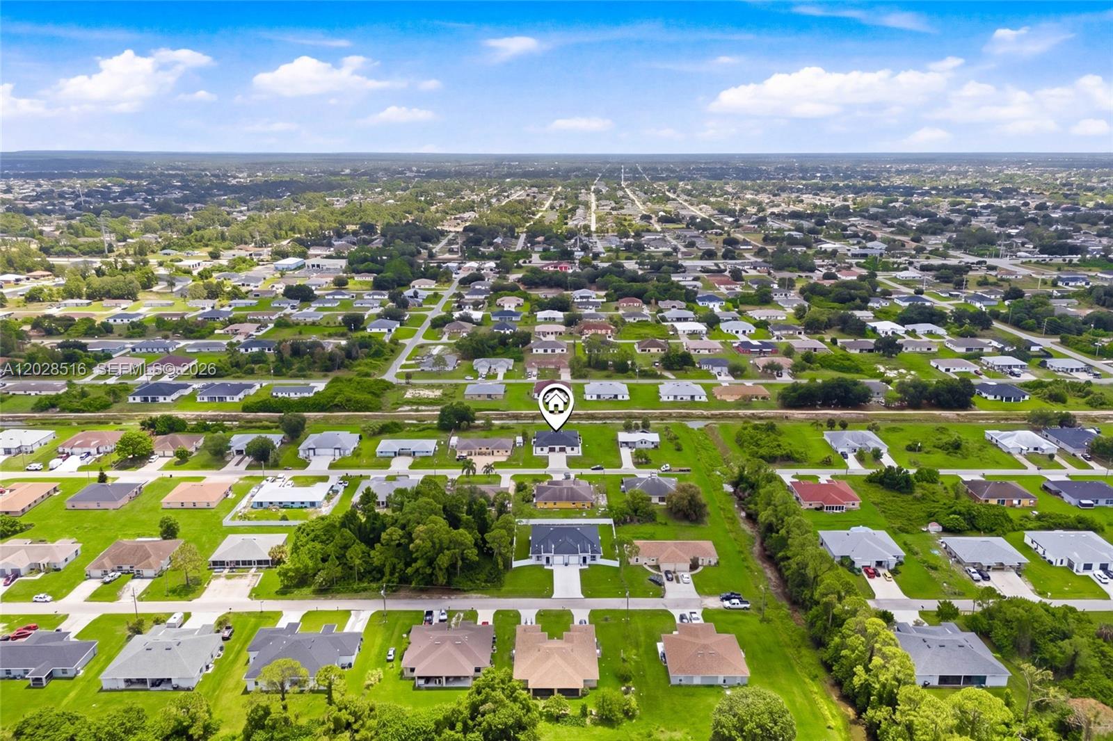 This aerial view shows a residential neighborhood with single-family homes and green lawns — 225/227 Hightower AVE S, Lehigh Acres FL 33973, LEHIGH ACRES, FL
