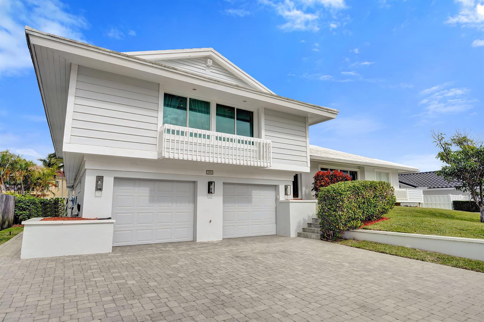 A two-story white house features a two-car garage, a balcony, and a paved driveway — 3001 NE 47th Street, Lighthouse Point FL 33064, LIGHTHOUSE POINT, FL