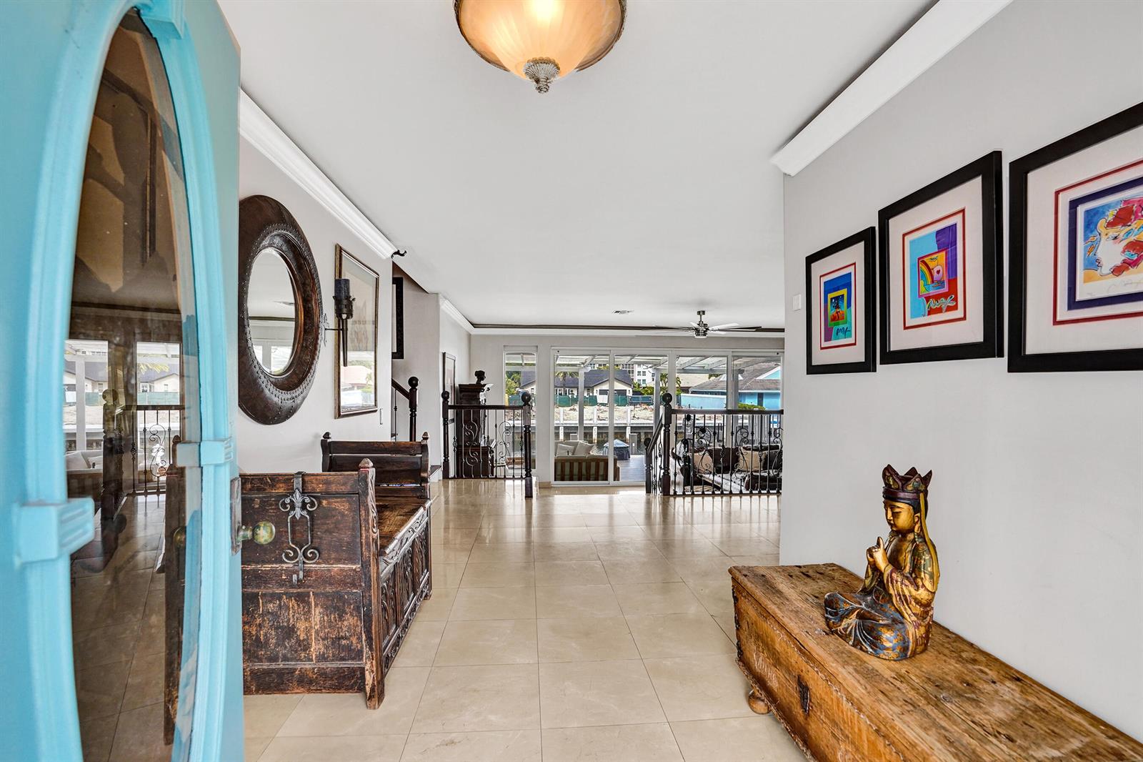 A bright foyer with tile flooring leads to a living area overlooking a waterfront deck — 3001 NE 47th Street, Lighthouse Point FL 33064, LIGHTHOUSE POINT, FL