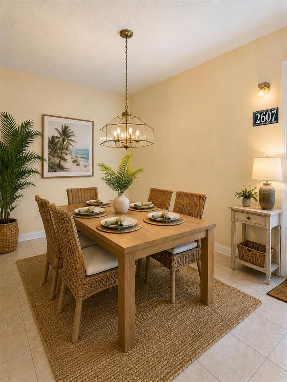 A dining room features a wooden table, wicker chairs, a pendant light, and a jute rug — 2607 RIVER PRESERVE COURT UNIT 2607, BRADENTON, FL