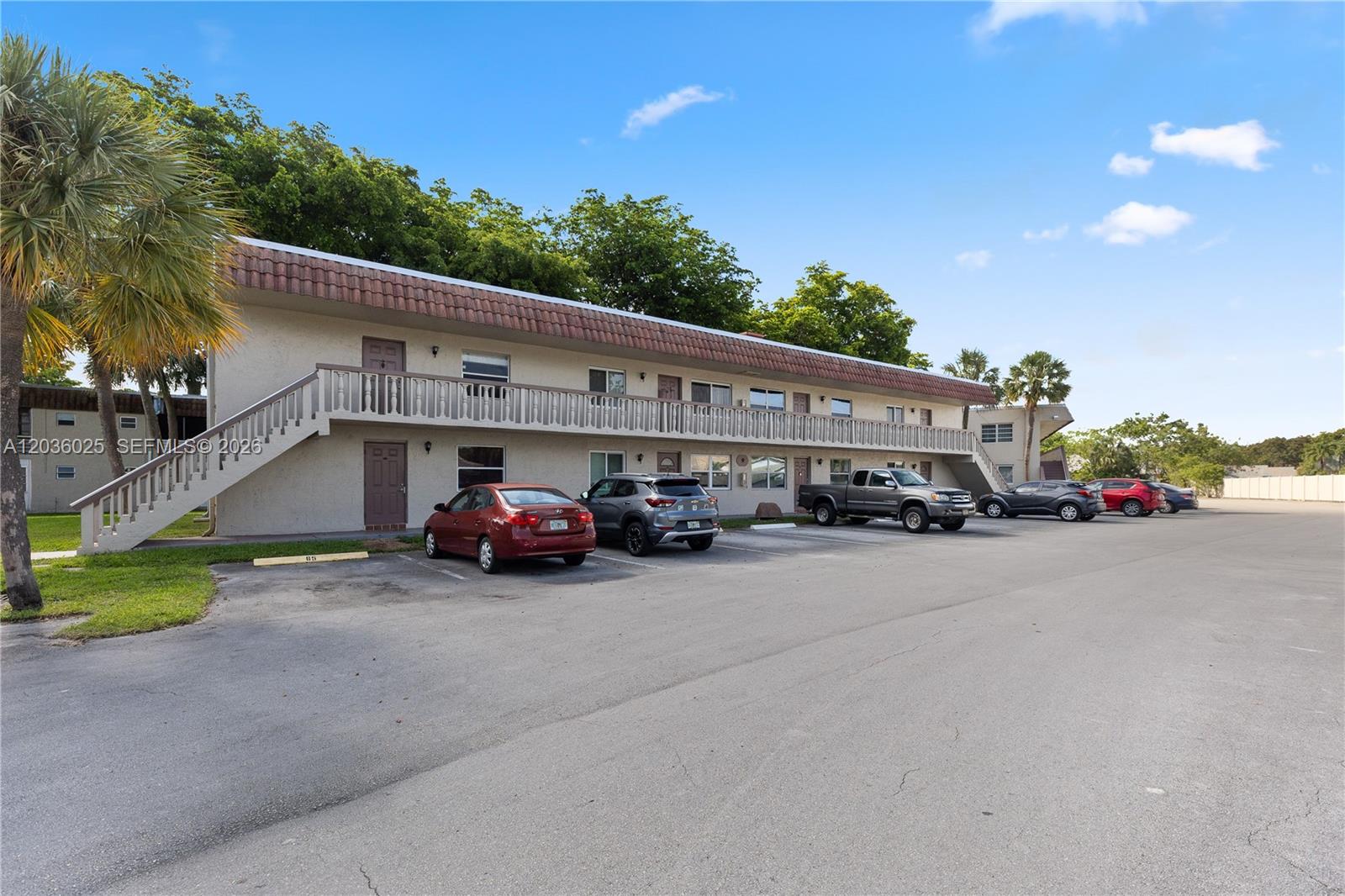 A two-story apartment building features a balcony, exterior stairs, and a parking lot — 3777 NW 78th Ave # 9C, Davie FL 33024, DAVIE, FL