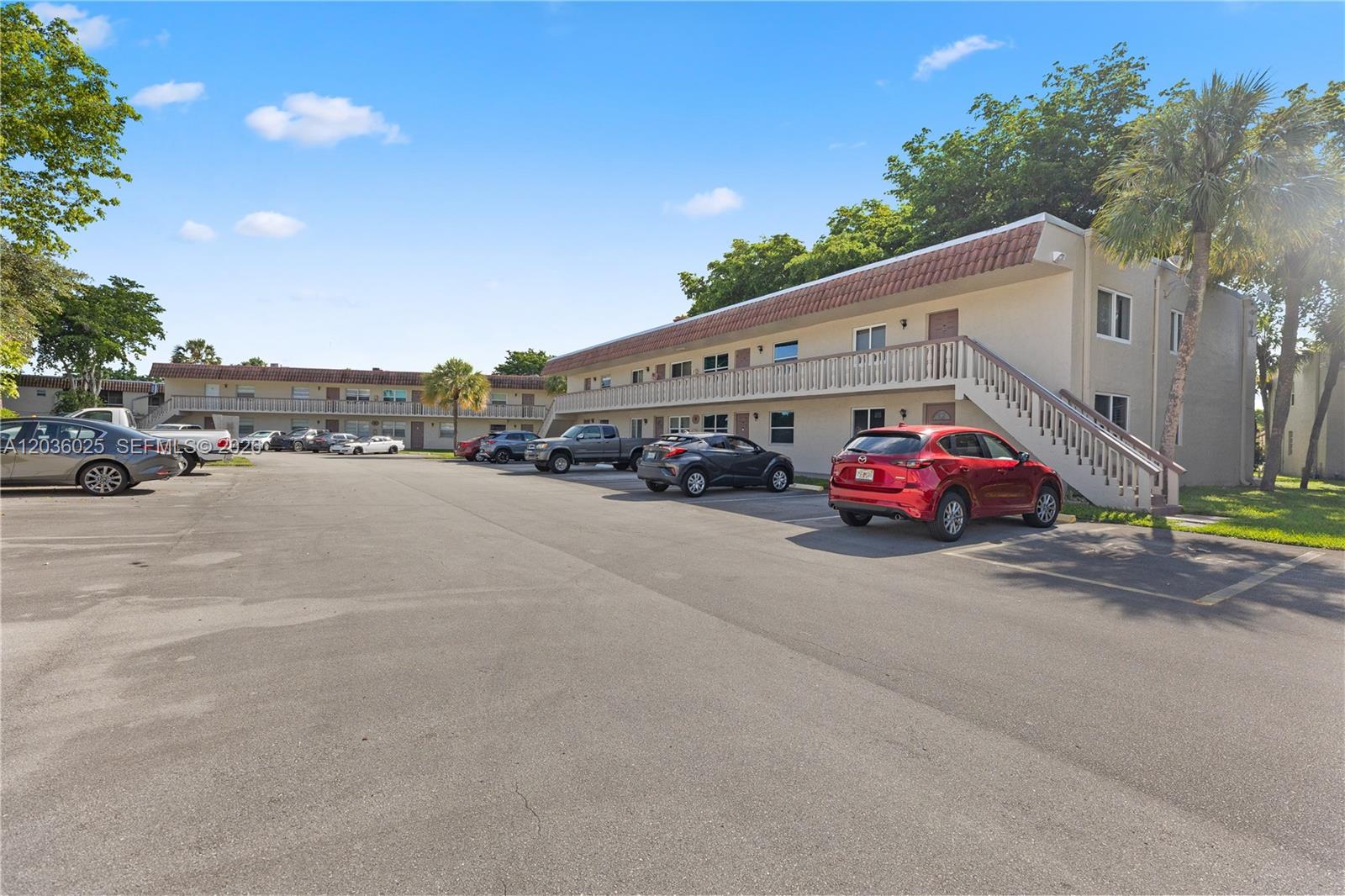 A two-story apartment building with exterior walkways and a parking lot in the foreground — 3777 NW 78th Ave # 9C, Davie FL 33024, DAVIE, FL