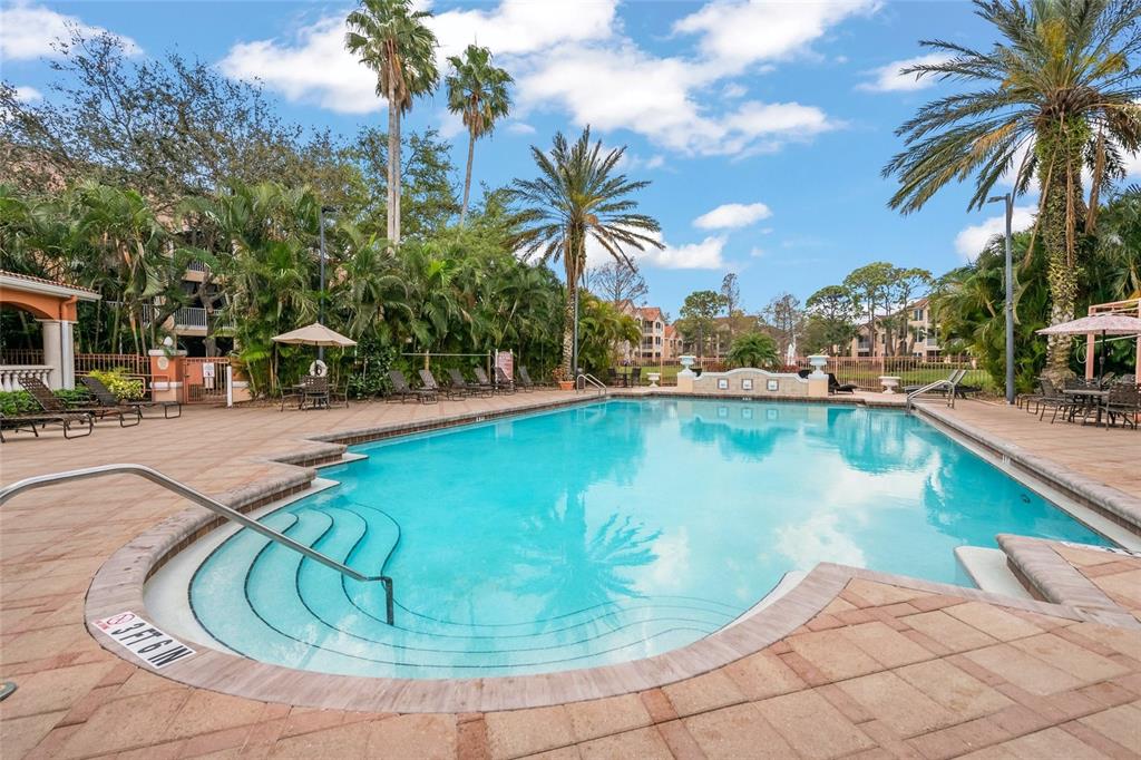 A swimming pool with steps and a surrounding patio area at an apartment complex — 4166 CENTRAL SARASOTA PARKWAY UNIT 533, SARASOTA, FL