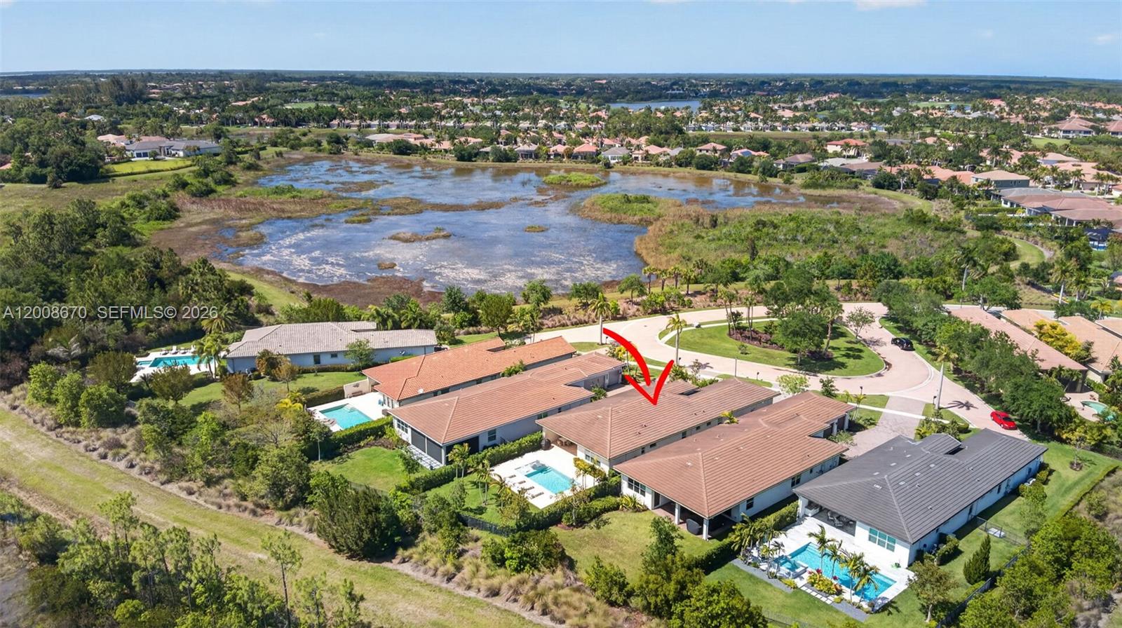 An aerial view shows a row of suburban homes with swimming pools near a lake — 10626 Starling Way, West Palm Beach FL 33412, WEST PALM BEACH, FL