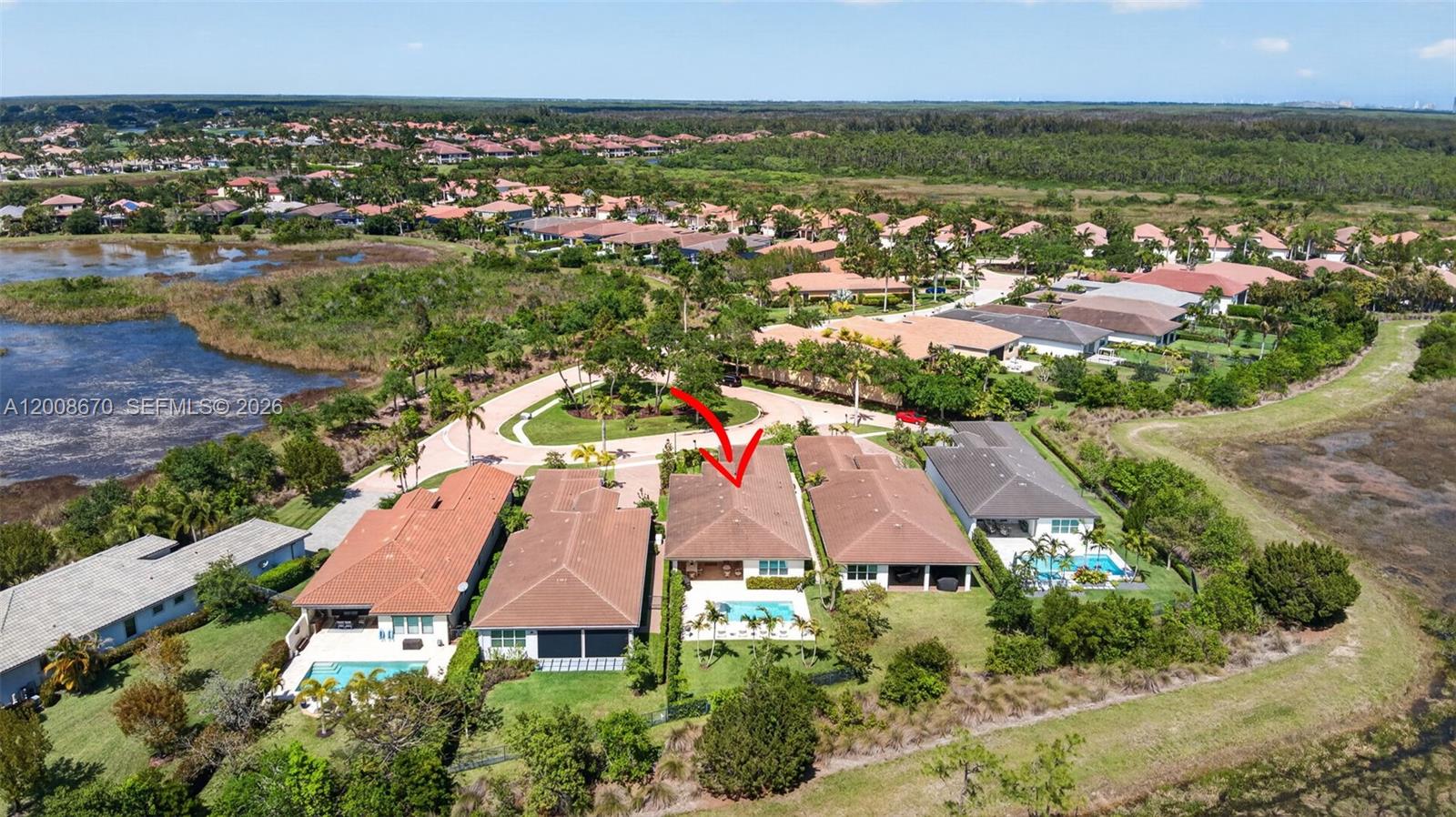 An aerial view shows a row of suburban houses with swimming pools near wetlands — 10626 Starling Way, West Palm Beach FL 33412, WEST PALM BEACH, FL