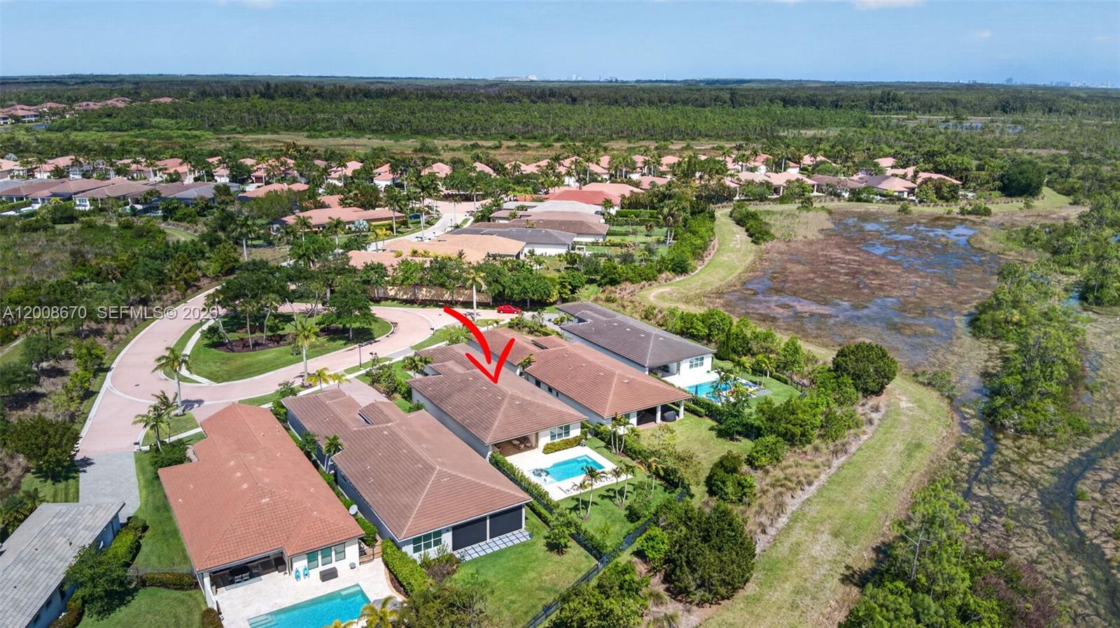 An aerial view shows a residential neighborhood with houses, swimming pools, and surrounding wetlands — 10626 Starling Way, West Palm Beach FL 33412, WEST PALM BEACH, FL