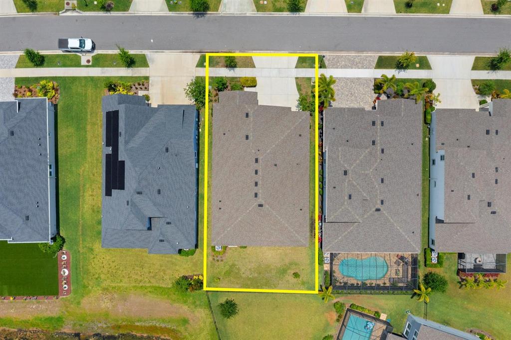 An aerial view shows a residential house lot outlined in yellow within a suburban neighborhood — 5406 LIMELIGHT DRIVE, APOLLO BEACH, FL