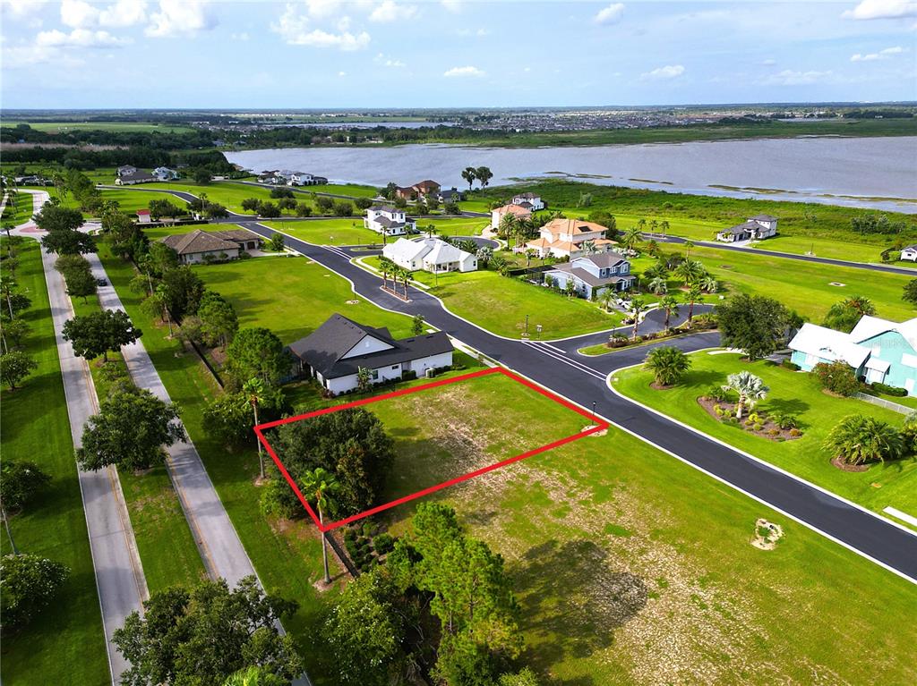 An aerial view shows a vacant residential lot outlined in red within a suburban neighborhood — 231 BLAZING STAR AVENUE, LAKE ALFRED, FL